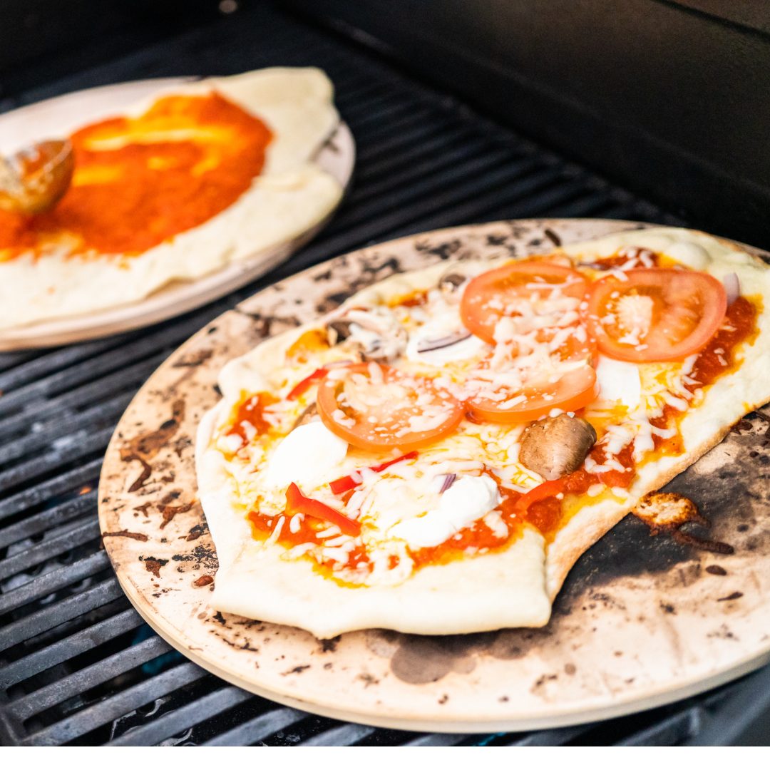pizza stones on grill with tomato pizza