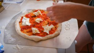 simple pizza with mozzarella cheese on a pizza peel
